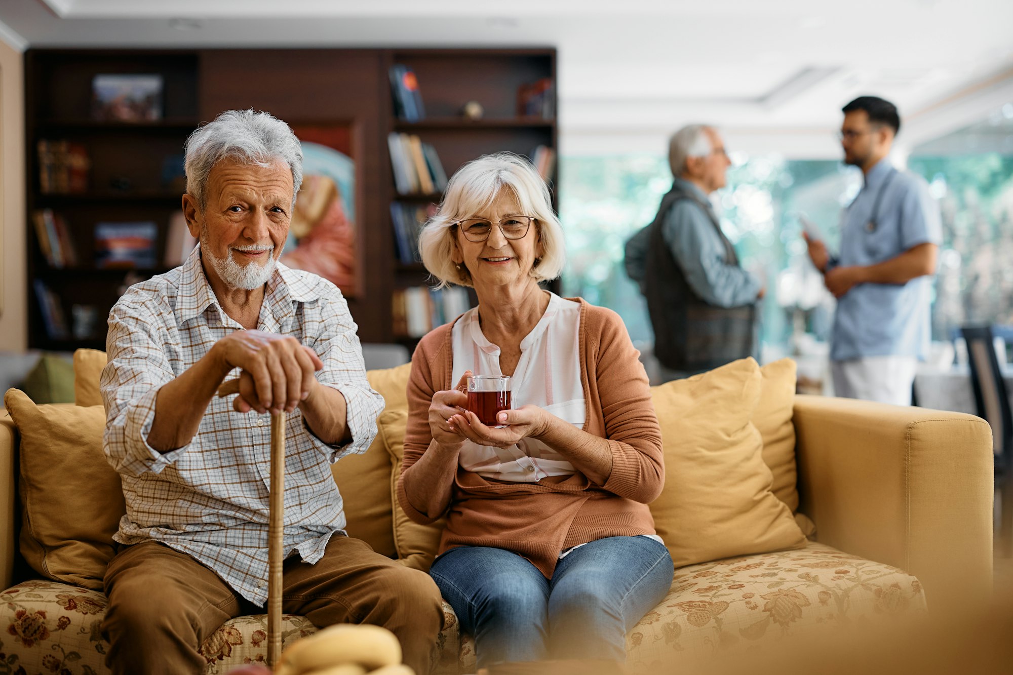 Happy mature couple at residential care home looking at camera.